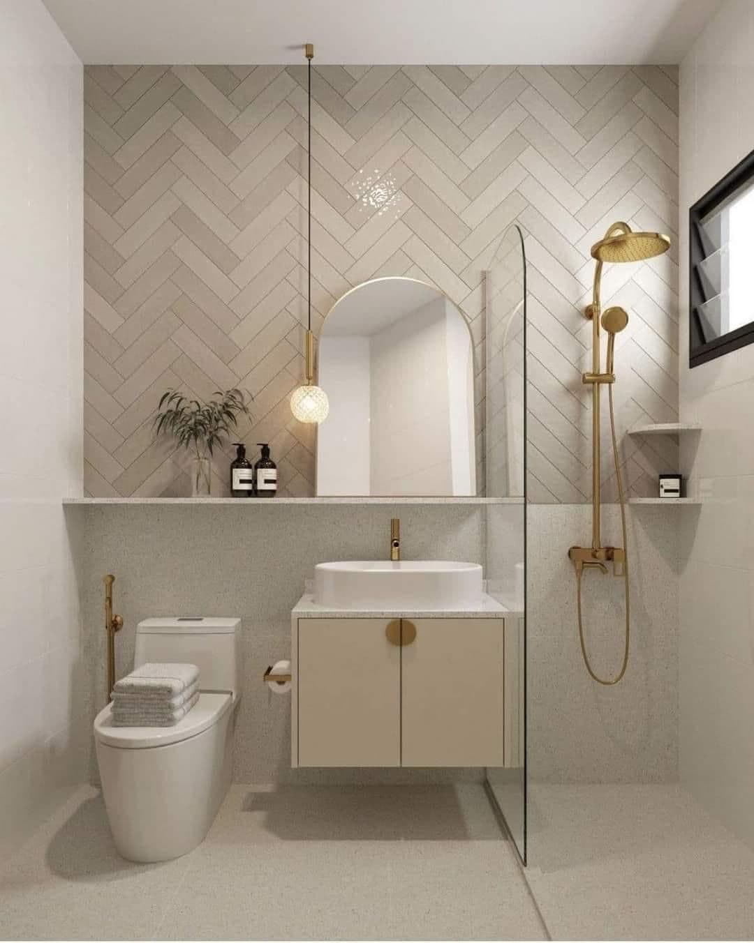 Herringbone-tiled bathroom with brushed-gold brassware and a wall-hung vanity