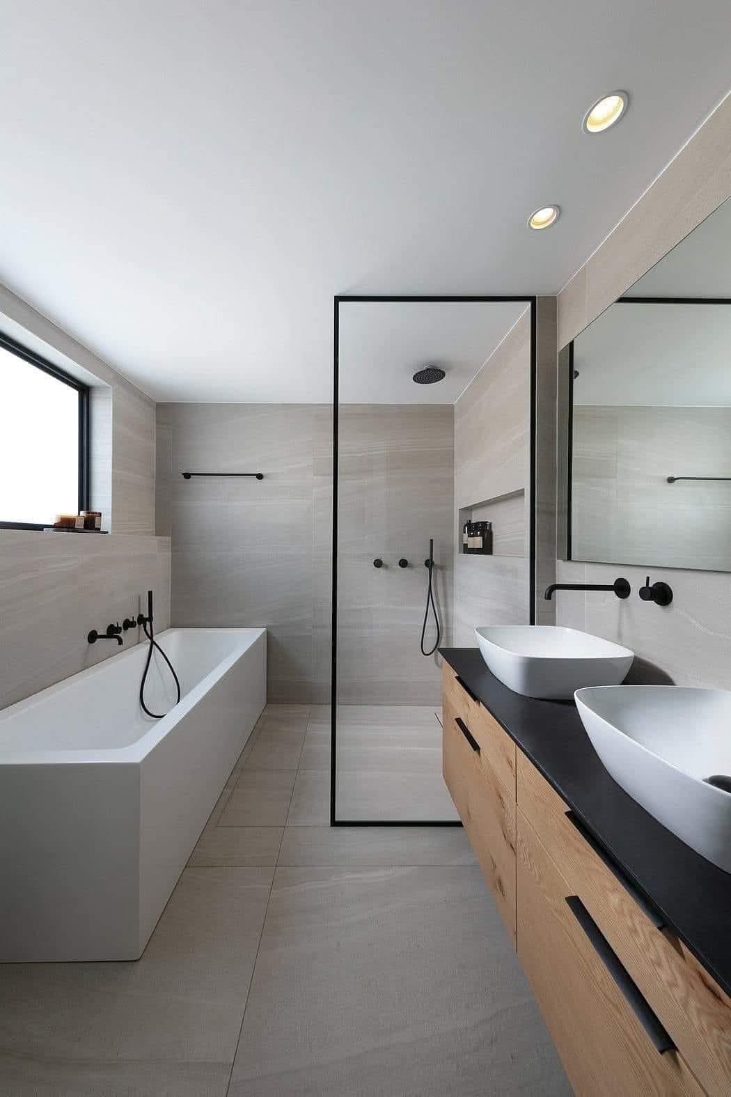Modern bathroom with a freestanding bath, a glass walk-in shower and twin oak-vanity basins with matte-black fittings