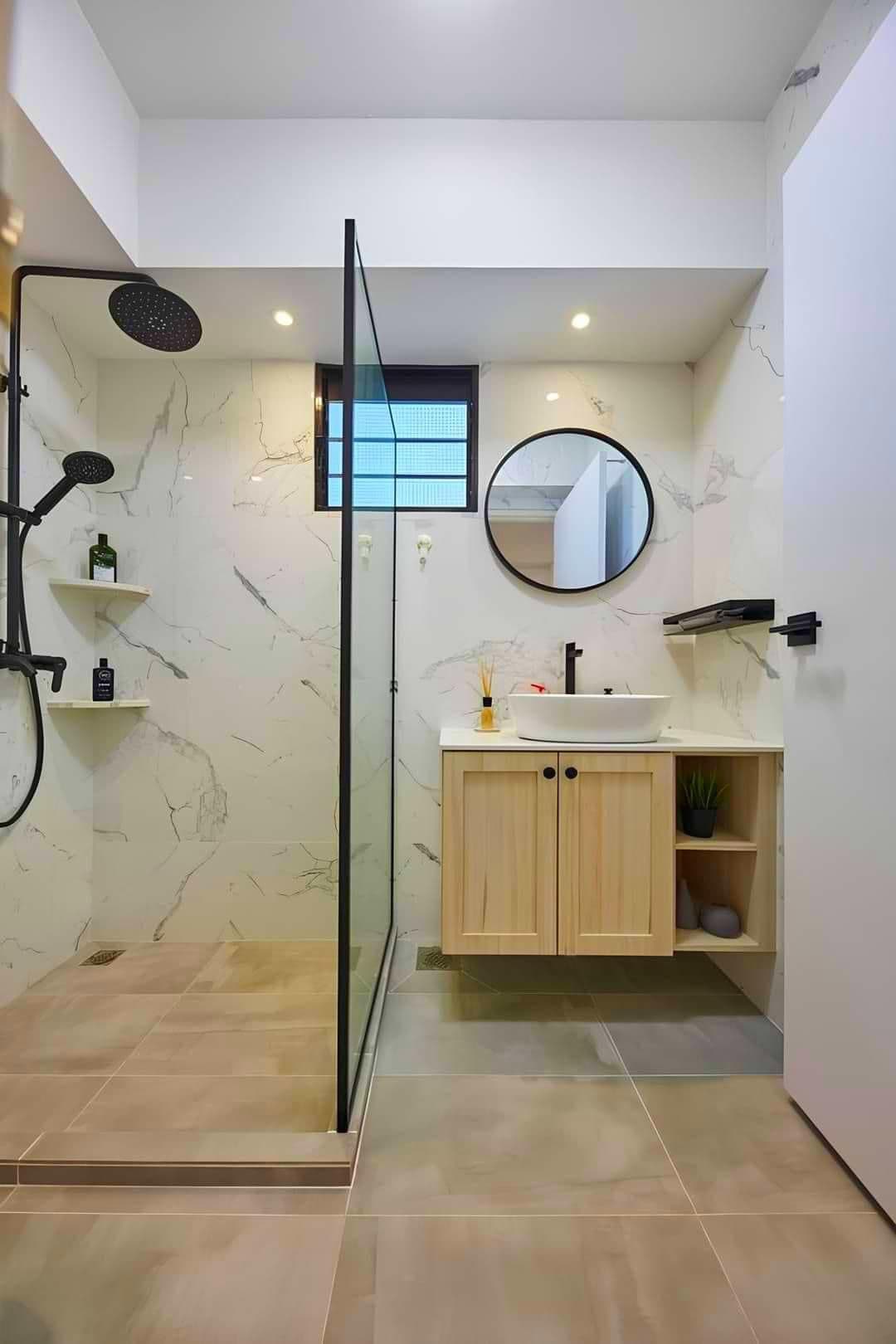 Marble walk-in wet room with a black-framed glass screen and an oak vanity